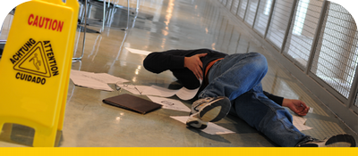 Man has fallen on floor next to caution warning sign